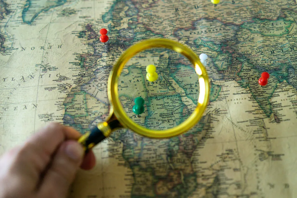 online location research for escape room business looking glass on map with pins